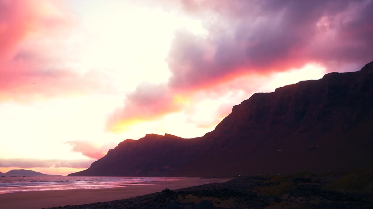 Risco de Famara bajo nubes rosas al atardecer