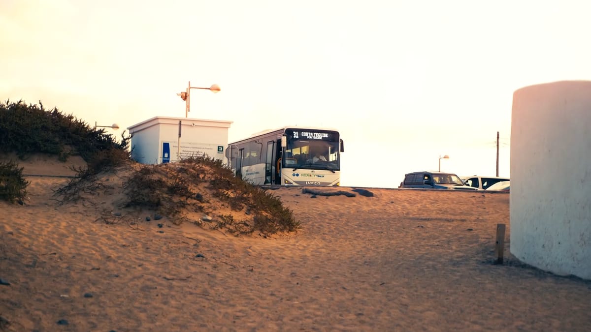 Dunas y casas de Famara con una guagua aparcada al fondo