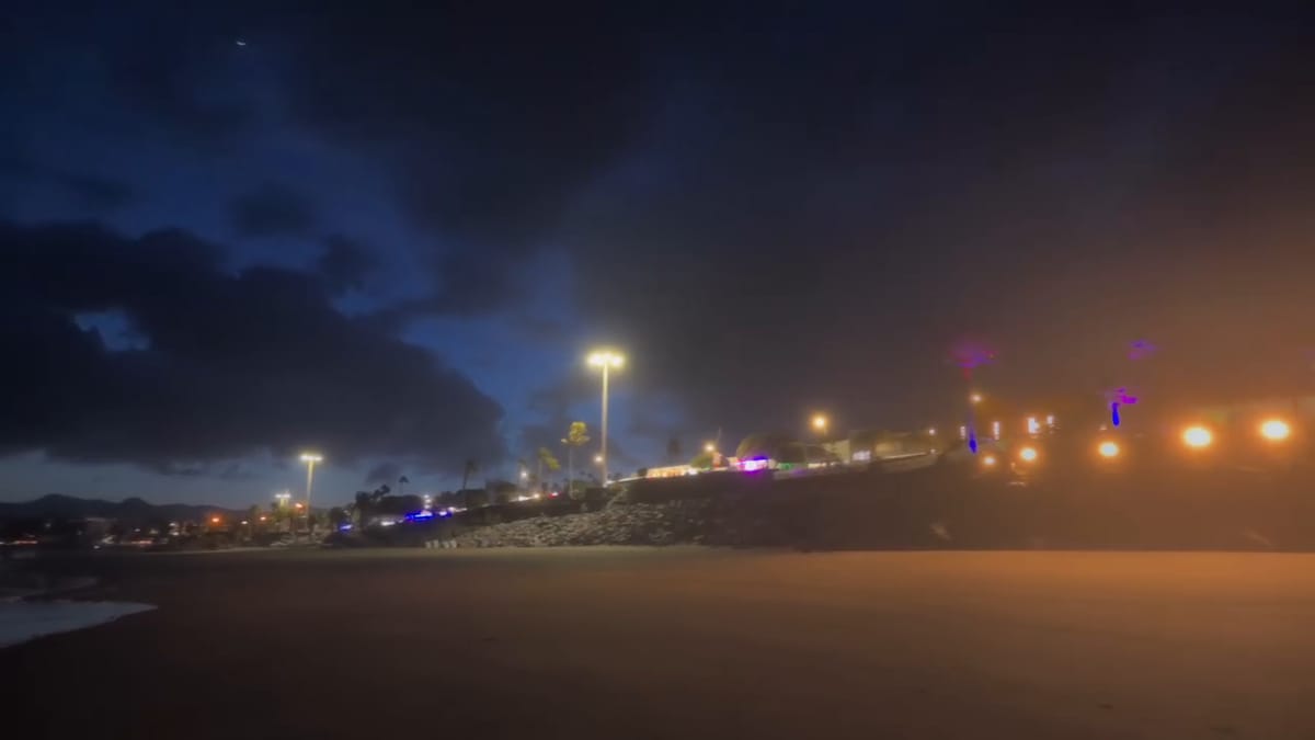 Playa de Puerto del Carmen de noche bajo un cielo nublado, con las luces del paseo