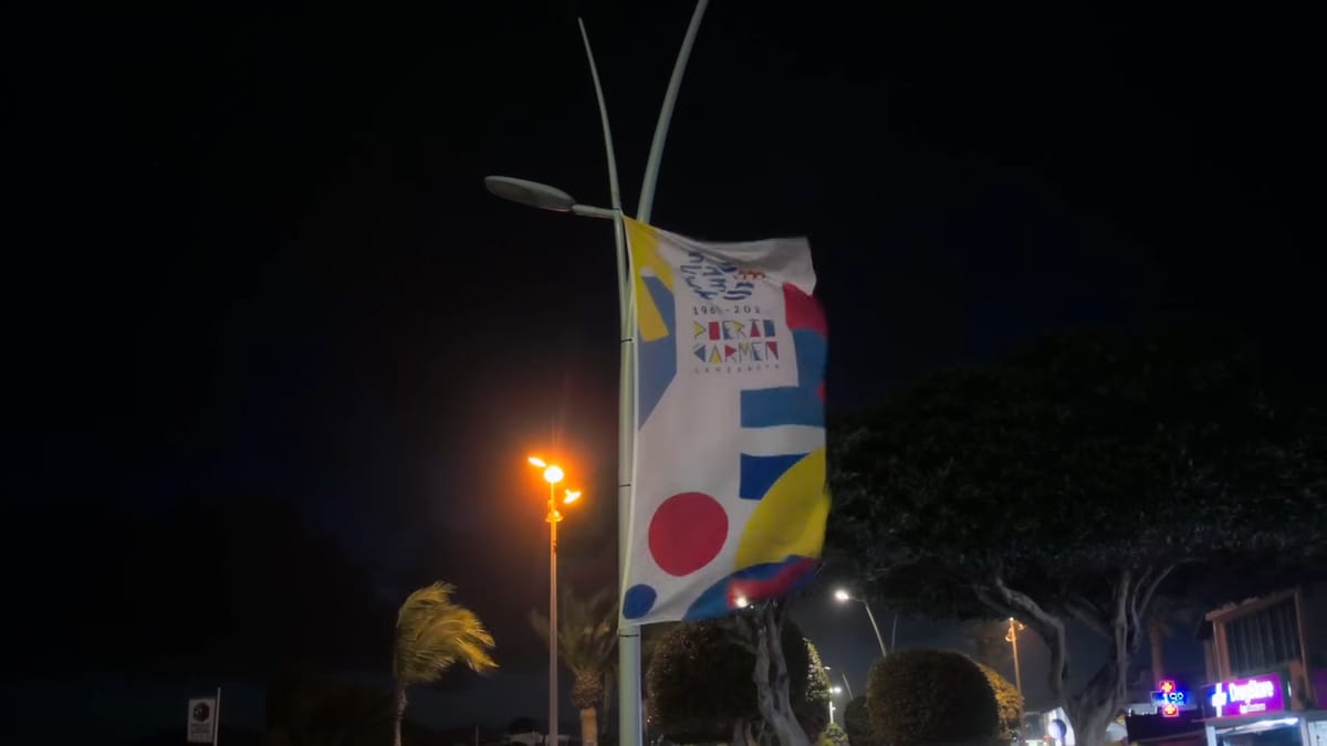 Farola y bandera de colores en el paseo de noche