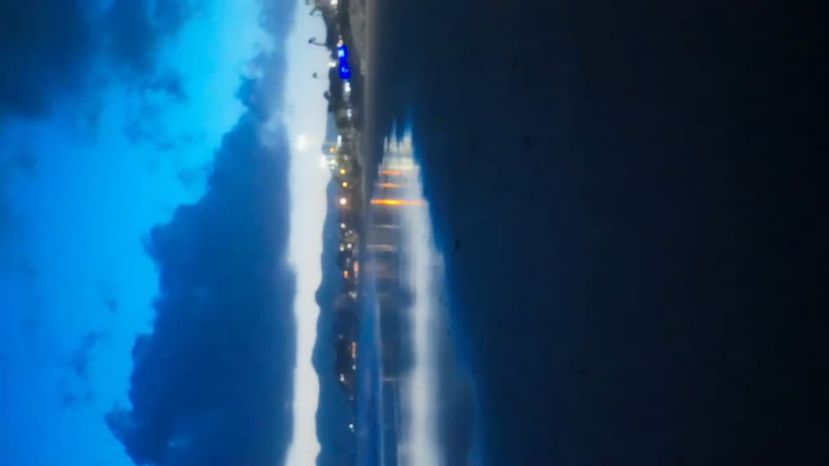 Plano girado del paseo marítimo iluminado bajo el cielo azul de la noche