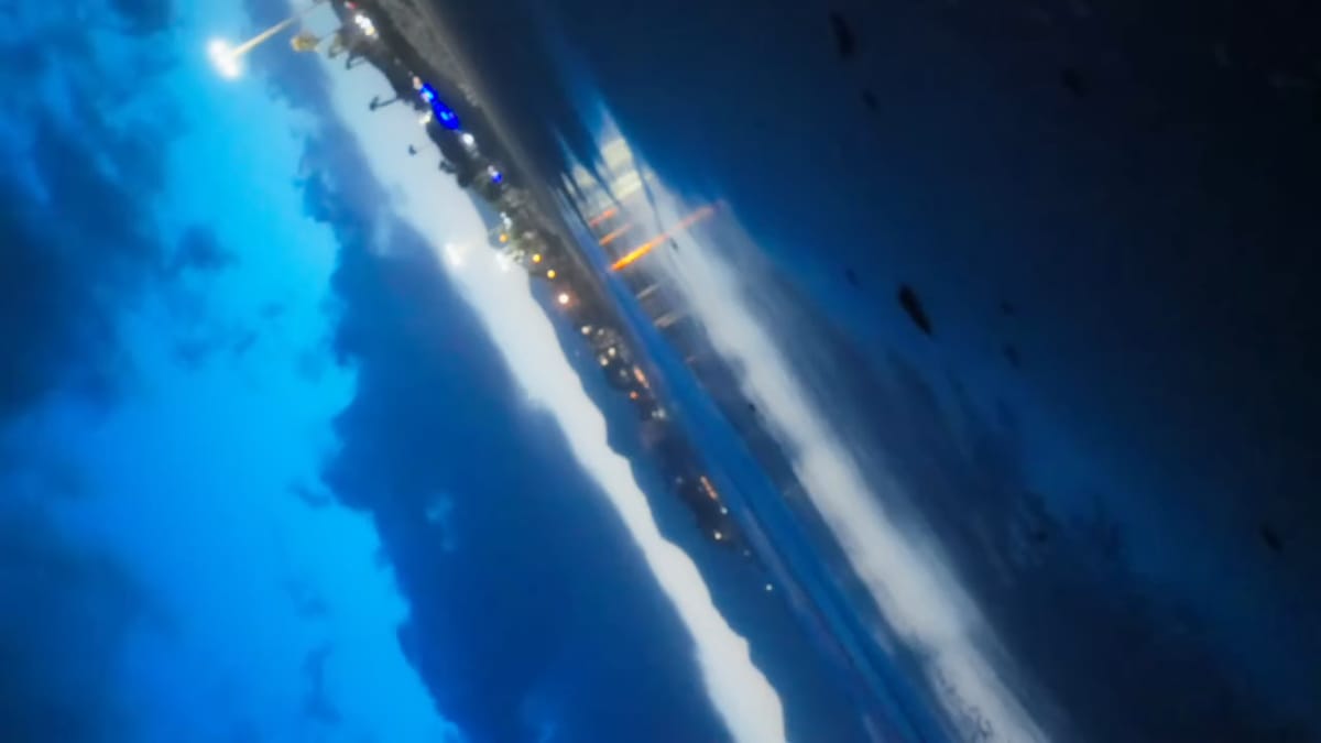 Plano invertido de la costa iluminada con el cielo azul abajo