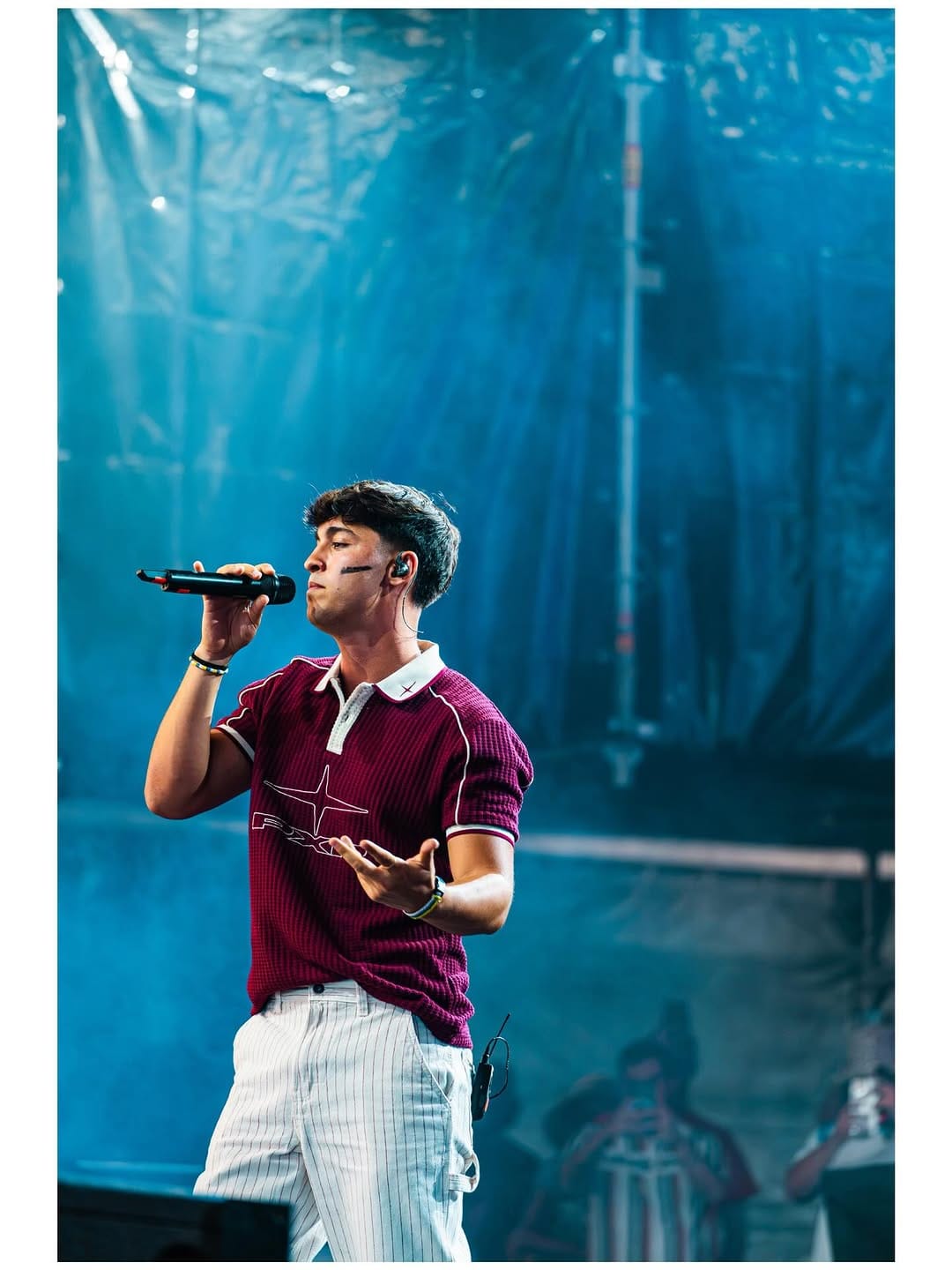 Cantante con polo granate en el escenario