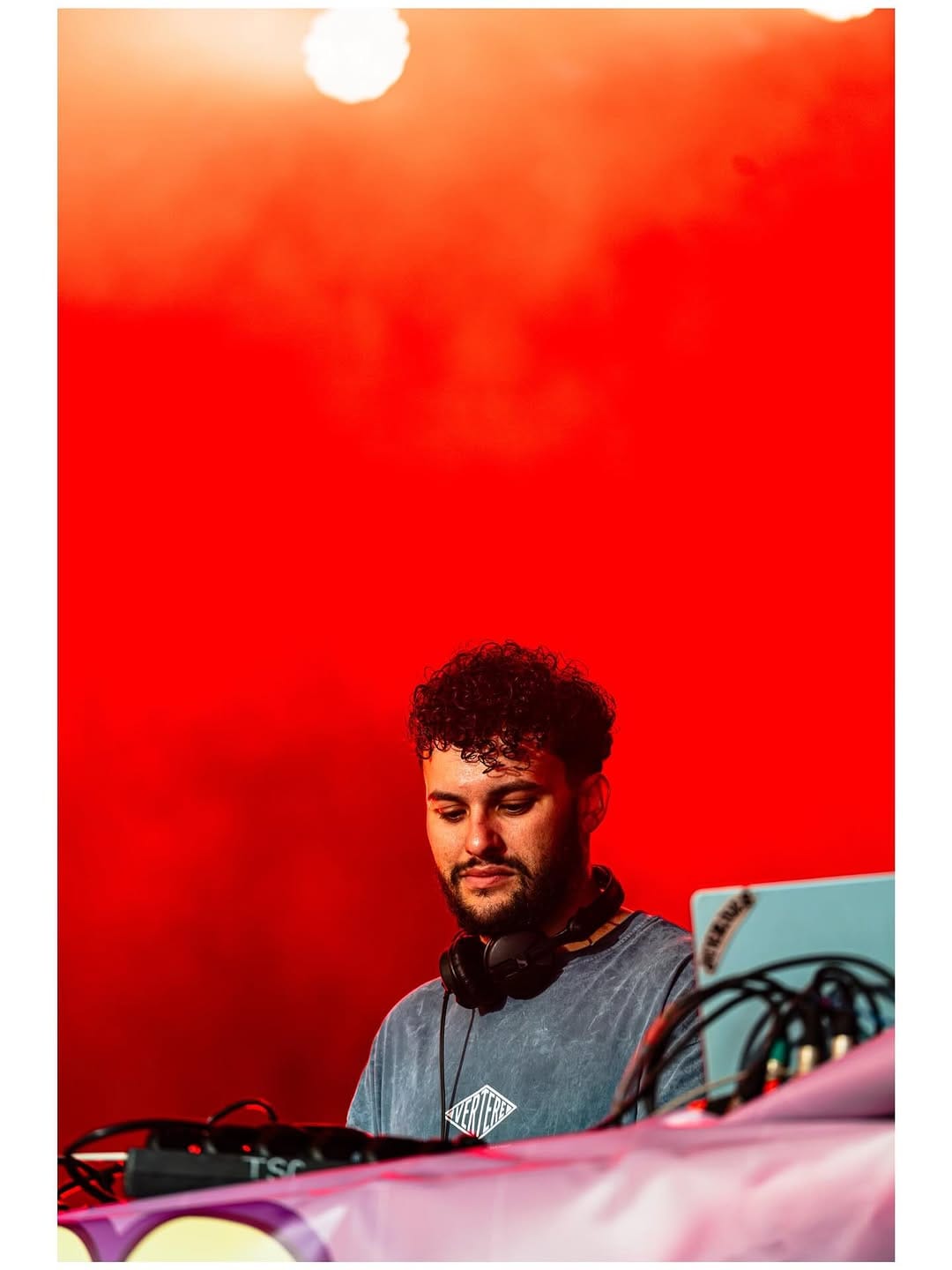 DJ en su mesa bajo luz roja