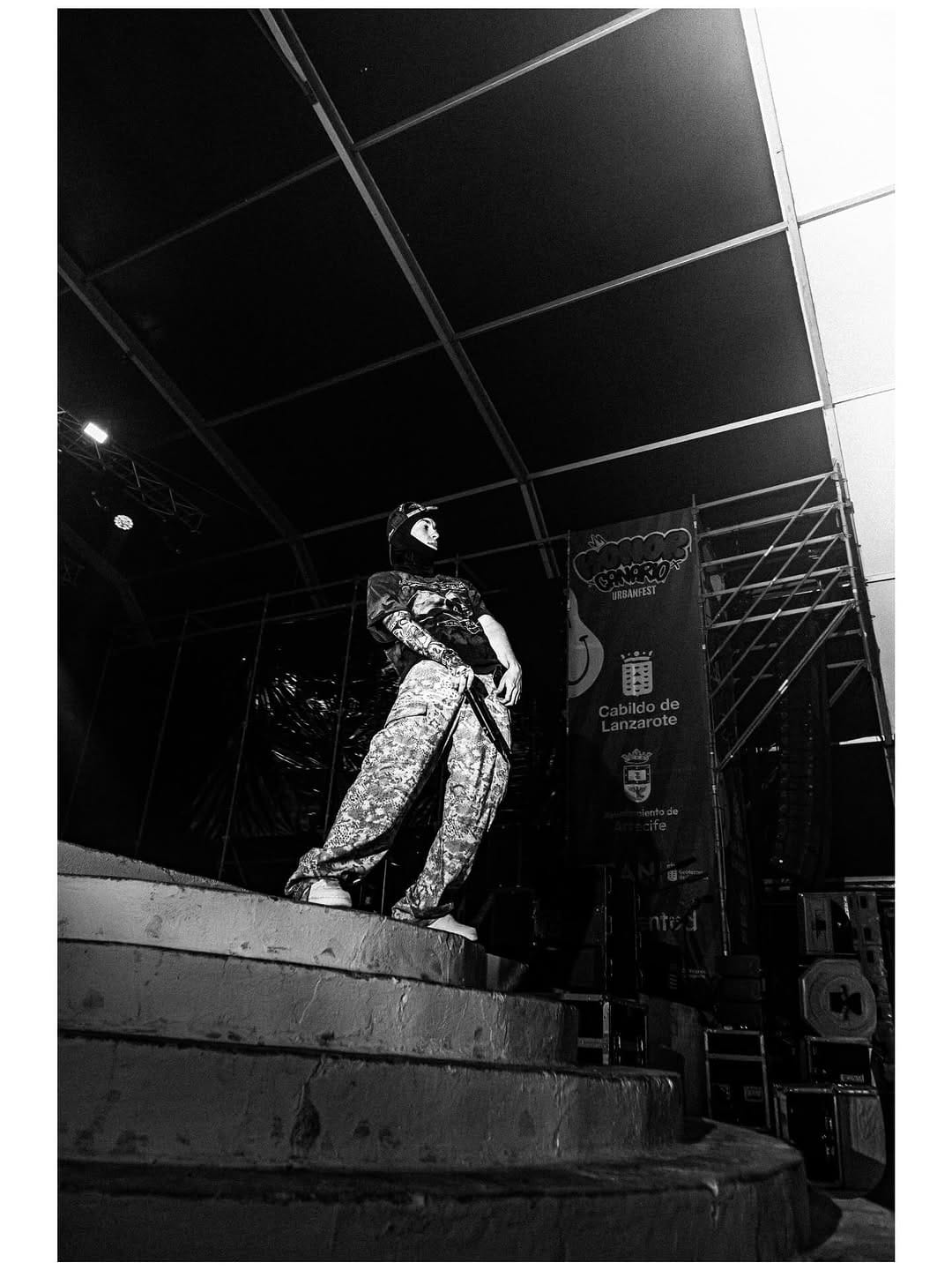 Artista con pasamontañas en blanco y negro sobre el escenario del festival