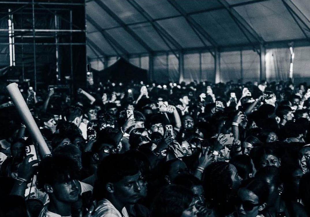 Público del festival en blanco y negro bajo la carpa