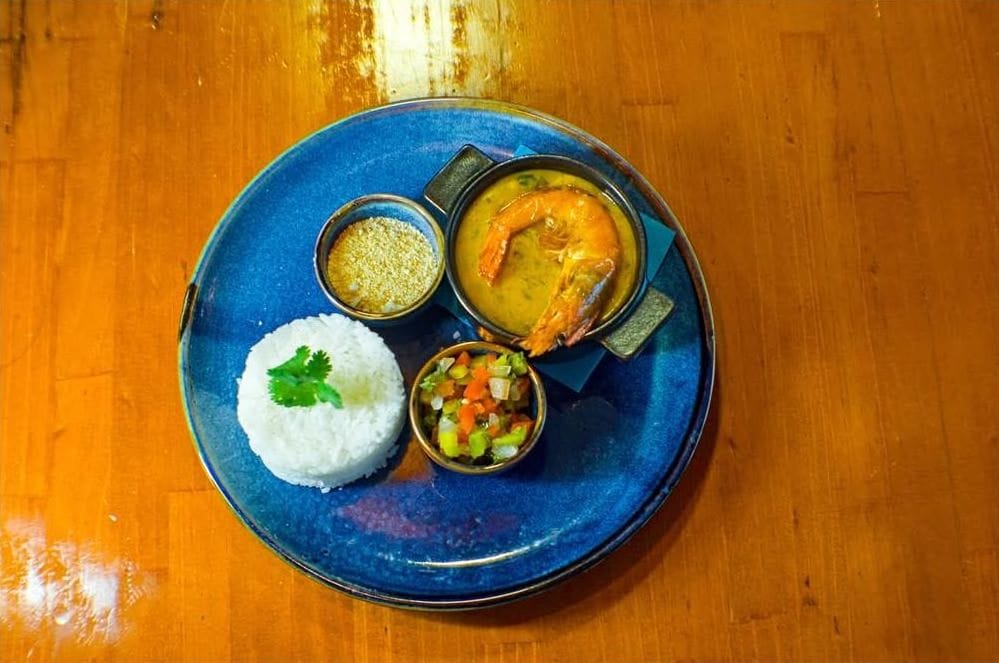 Vista cenital de un plato con arroz, langostinos y salsas
