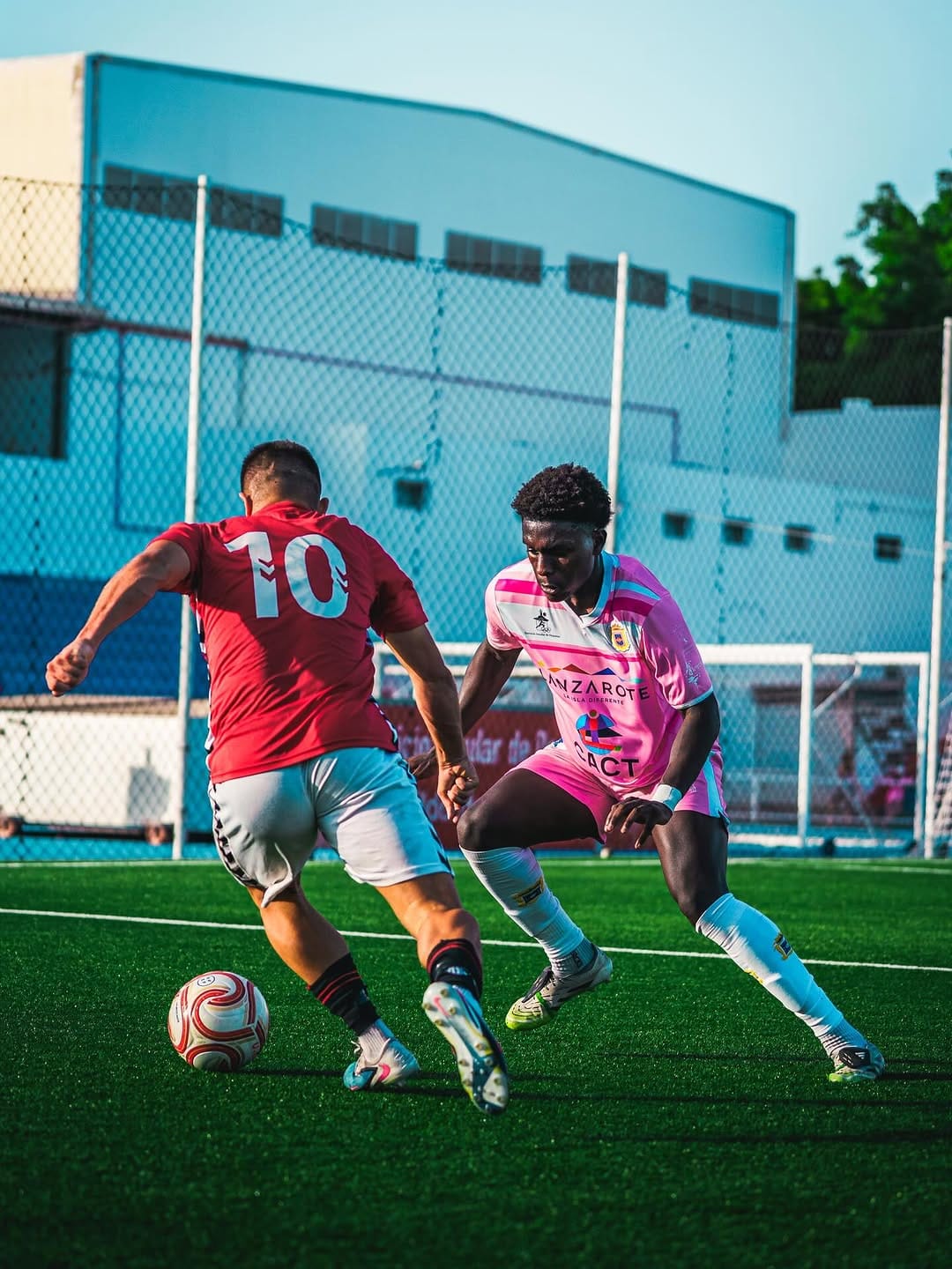 Regate entre el dorsal 10 de rojo y un jugador de rosa