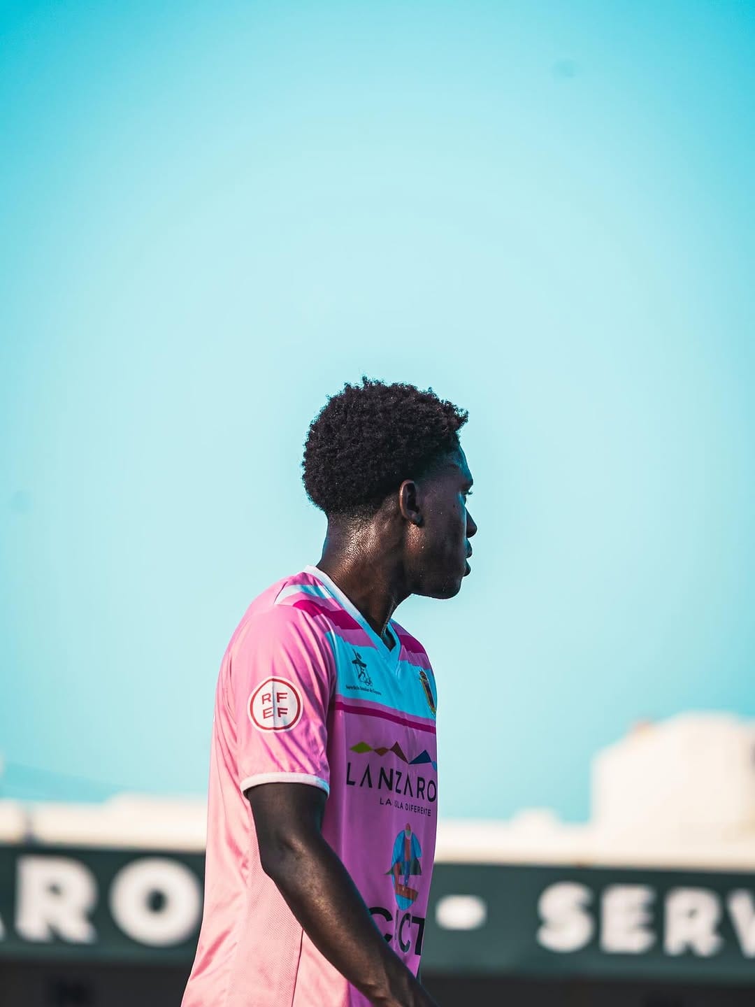 Jugador de la UD Lanzarote de perfil con la camiseta rosa del club