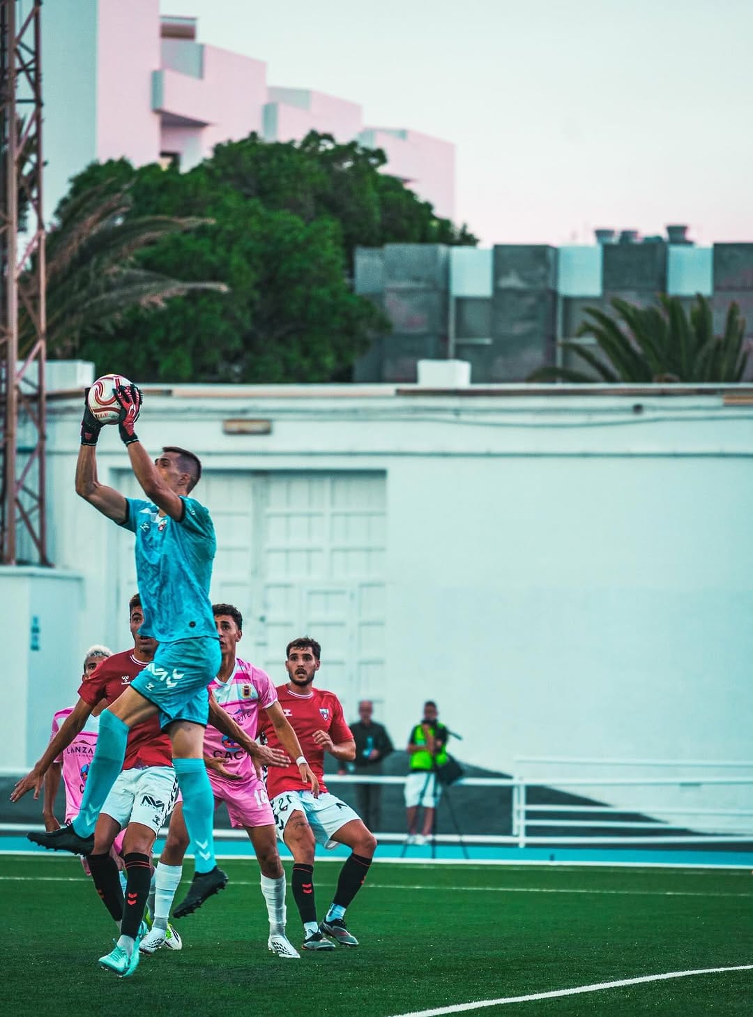 Un portero atrapa el balón por alto entre varios jugadores
